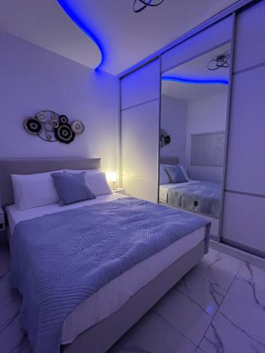 a bedroom with a large bed and a mirror at Salamina Downtown Apartment East in Salamina