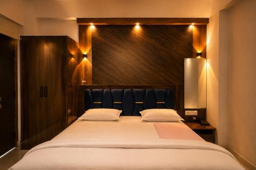 a bedroom with a large bed with a black headboard at Hotel Prince Paradise in Patna