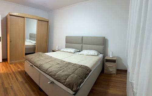 a bedroom with a large bed and a mirror at Garden View Apartment in Čapljina
