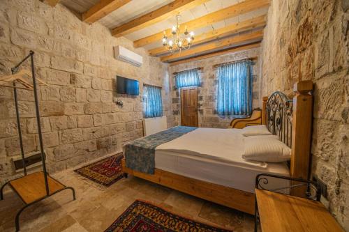 a bedroom with a bed in a stone wall at Chelebi Cave House in Göreme