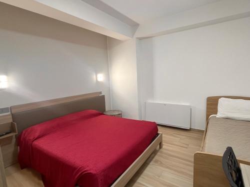 ein Schlafzimmer mit einem Bett mit einer roten Decke in der Unterkunft La Terrazza in Cotronei