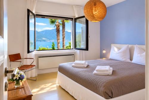a bedroom with a bed and a large window at Casa Panorama in Brissago