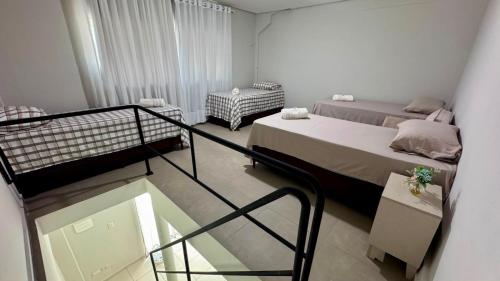 a small room with two beds and a balcony at Saif Economy Apart in Paranaguá