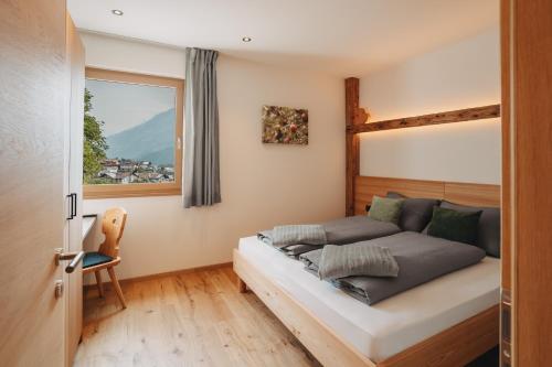 a bedroom with a bed and a window at Innersennerhof in Rifiano