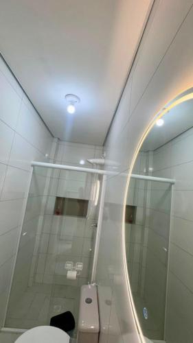 a bathroom with a toilet and a mirror at Saif Economy Apart in Paranaguá