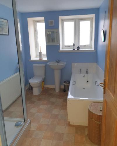 a bathroom with a tub and a toilet and a sink at Old School, Spean Bridge - fun, friendly, relaxed in Spean Bridge