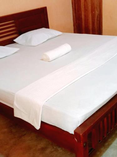 a bed with white sheets and pillows on it at Ceylon Salt & Soul in Arugam Bay