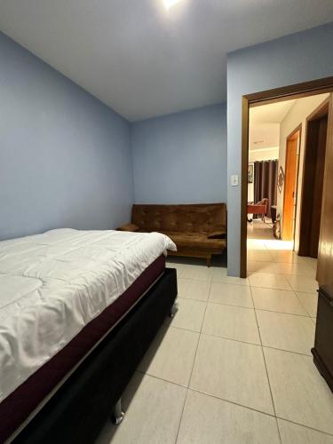 a bedroom with a bed and a living room at Apartamento Unisc in Santa Cruz do Sul