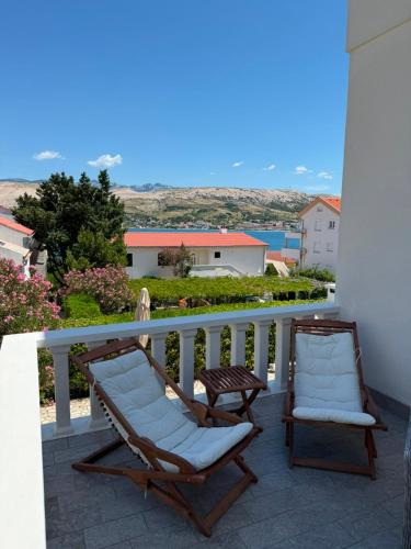 two chairs sitting on a balcony with a view at Apartments Anastazija in Pag