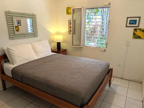 a bedroom with a bed and a window at Simberts Apartments in Maya Beach