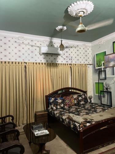 a bedroom with a bed with curtains and a table at Faran inn guest house in Hyderabad