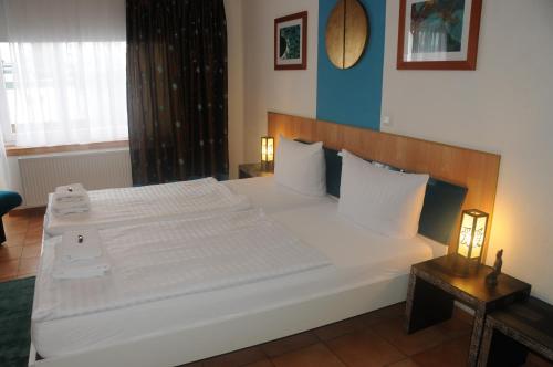 a bedroom with a large bed with white sheets at Pension Bella Vista in Bochum