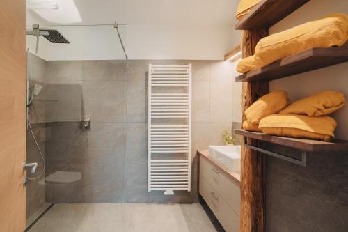 a bathroom with a shower and a sink and towels at Innersennerhof in Rifiano