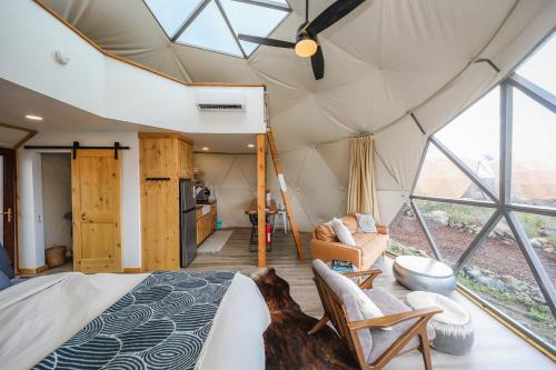 a bedroom in a tent with a bed and chairs at Pure Heart Retreat in Cody
