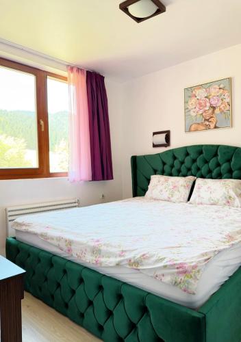a bed with a green tufted headboard in a bedroom at VIP Complex in Sarnitsa