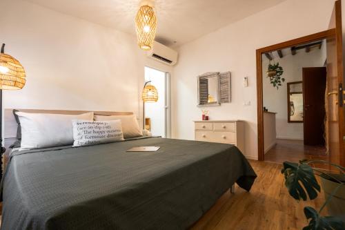 a bedroom with a bed with a black blanket and a mirror at Porta Toscana in Poggibonsi