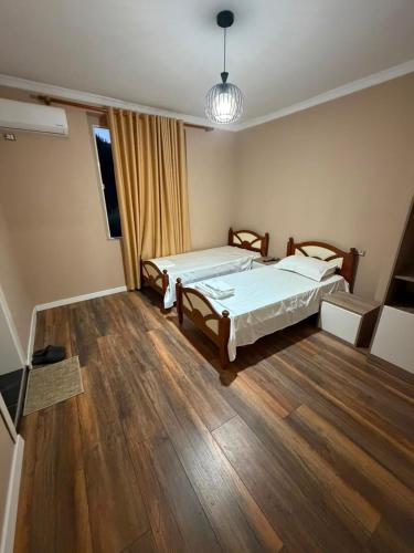 a bedroom with two beds and a wooden floor at Hotel, Bar, Restaurant Beni in Vlorë