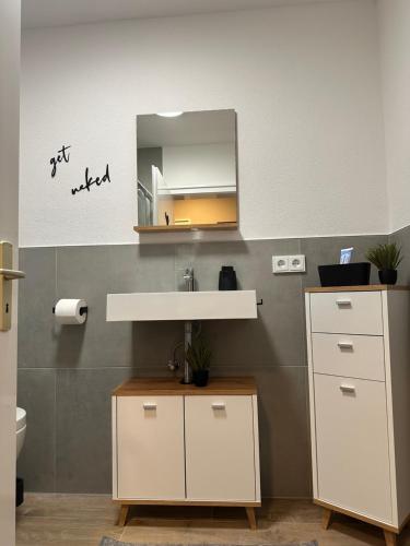 a bathroom with a sink and a mirror at Ferienwohnung zum Buchhellertal in Burbach