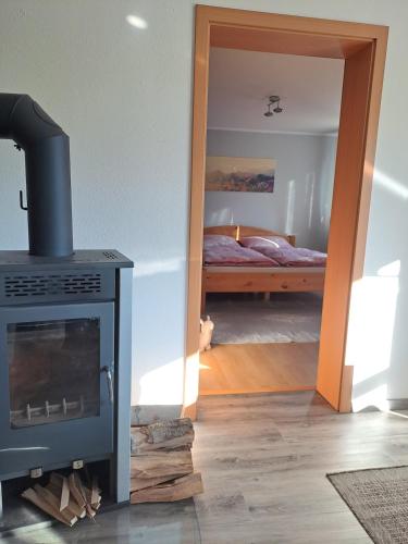 a room with a fireplace and a bedroom with a bed at NaturGenuss Wittgenstein in Bad Laasphe