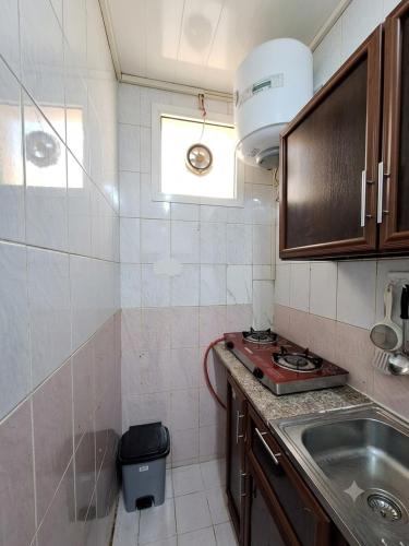 a small kitchen with a sink and a window at Hidden Villa in Al Ain