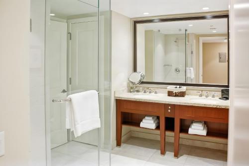 a bathroom with a shower and a sink and a mirror at Ocean View One Bedroom at Honua Kai!! in Lahaina