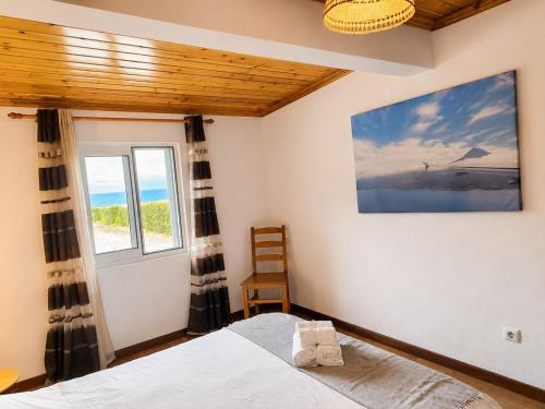 a bedroom with a bed and a window at Adega do Carlos Pinheiro in São Roque do Pico