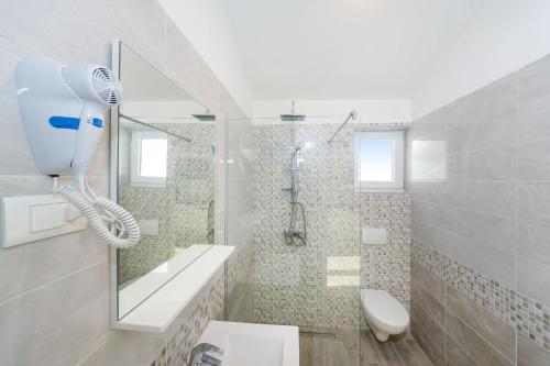 a white bathroom with a shower and a toilet at Apartment Paulo&Lorenco in Sveti Filip i Jakov