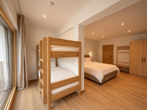 a bedroom with a bunk bed and a large window at BASE Achensee - Opening August 2026 in Achenkirch