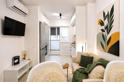a living room with a couch and chairs and a tv at Sasha Wave Studio in Popeşti-Leordeni
