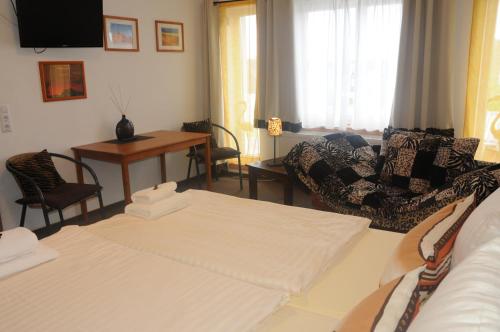a living room with a bed and a couch and a table at Pension Bella Vista in Bochum