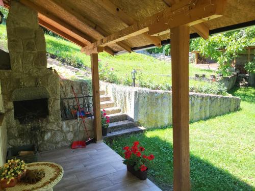 a patio with a stone wall and a waterfall at Deda Mrazova kućica in Knić
