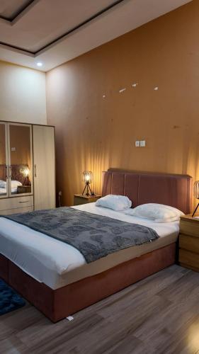 a bedroom with a large bed and a mirror at Belle Villa Kassonyah, Conakry in Conakry