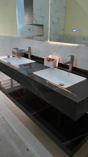 a bathroom counter with two sinks and a mirror at Belle Villa Kassonyah, Conakry in Conakry