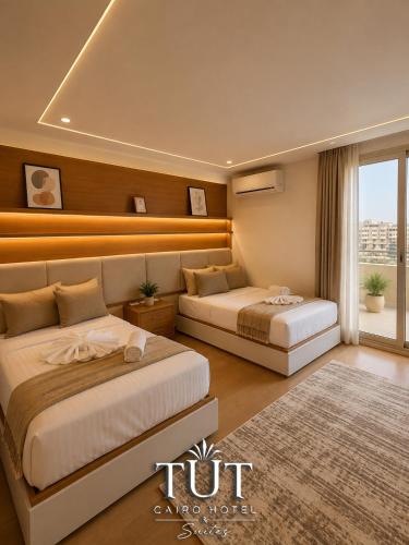 a hotel room with two beds and a window at TUT Cairo Hotel & Suites in Cairo