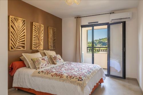 a bedroom with a bed with a view of a balcony at Le Cocon d'Orezza - Appart Climatisé avec Balcon in Penta-di-Casinca