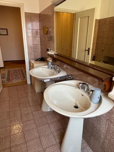 a bathroom with two sinks and a mirror at Santa Marta Apartment in Biella