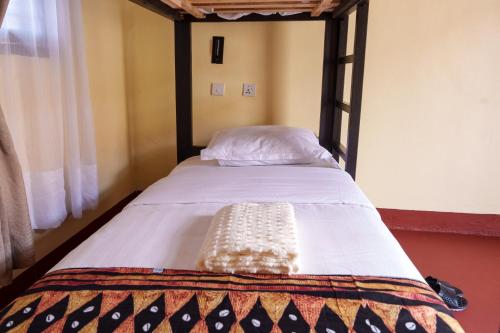 a bed in a room with a wooden bed frame at Elikai Hostels 