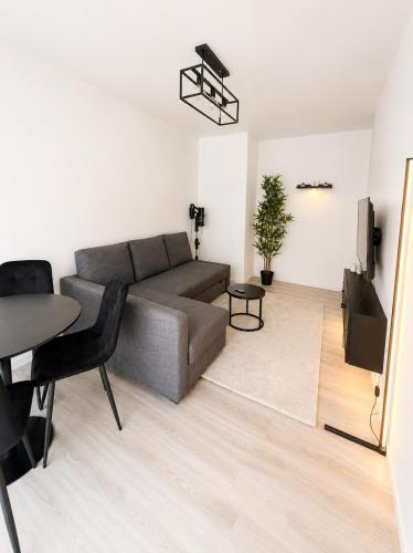 a living room with a couch and a table at LorOtel - Frontiere - Aeroport in Saint-Louis