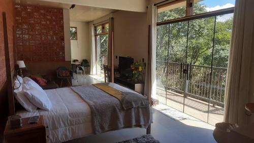 a bedroom with a bed and a large window at Loft Montclair in Nova Lima
