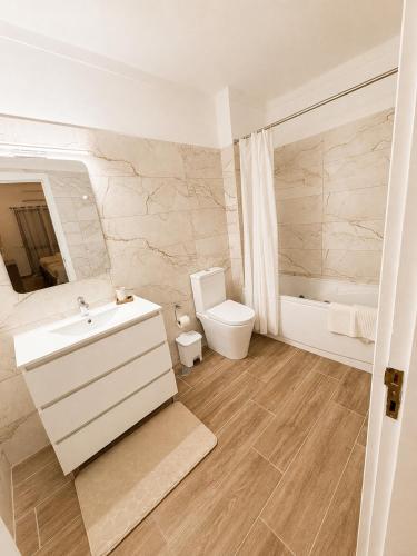 a white bathroom with a sink and a toilet at Casa Mar by Living & Co in Albufeira