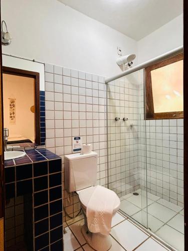 a bathroom with a toilet and a sink and a shower at Pousada Casa de Inaê in Itacaré