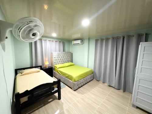 a bedroom with two beds and a fan at posada nativa NIYKA in Casabaja