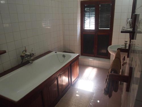 a bathroom with a bath tub and a sink at The Old Boma Hotel in Mtwara