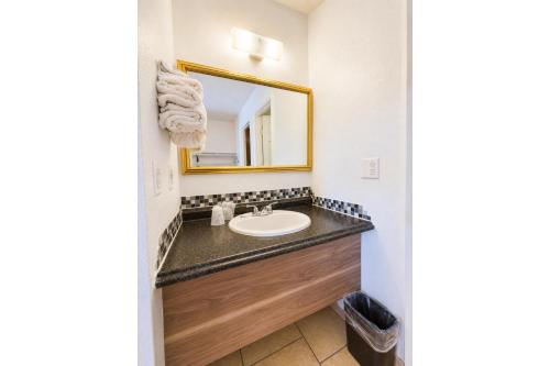 a bathroom with a sink and a mirror at Solano Inn Vallejo Napa Valley - Six Flags in Vallejo