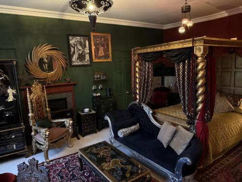 a bedroom with a bed and a couch and a chair at The Covenstead in Glastonbury
