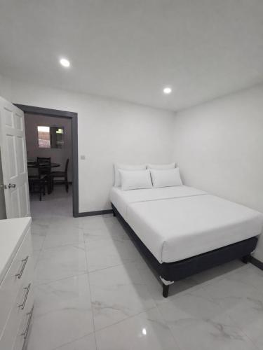 a white bed in a white room with a table at Tranquil Haven in Bellevue