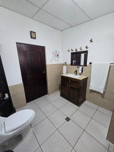 a bathroom with a sink and a toilet and a mirror at El Refugio - Hospedaje y Eventos in San Lucas Sacatepéquez