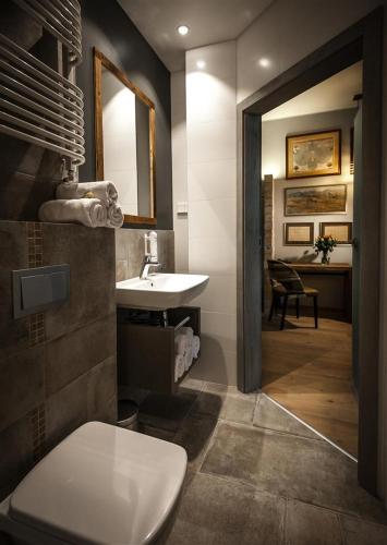 a bathroom with a sink and a toilet and a mirror at Akademia Kuraszków in Kuraszków
