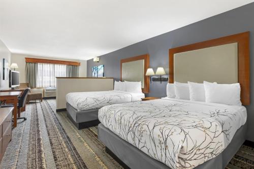 a hotel room with two beds and a desk at Best Western Newberg Inn in Newberg