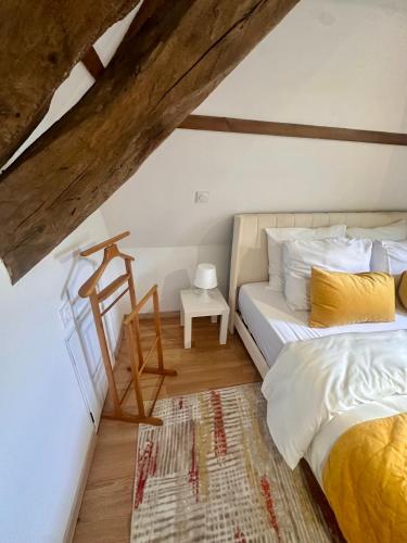 a bedroom with a bed and a table at Le loft sous les colombages in Gouffern en Auge